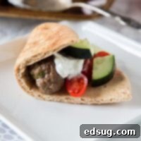 One-Pan Greek Meatballs 7 Delicious Sheet Pan Greek Meatballs ready to be served with homemade tzatziki sauce and pitas for making gyros.