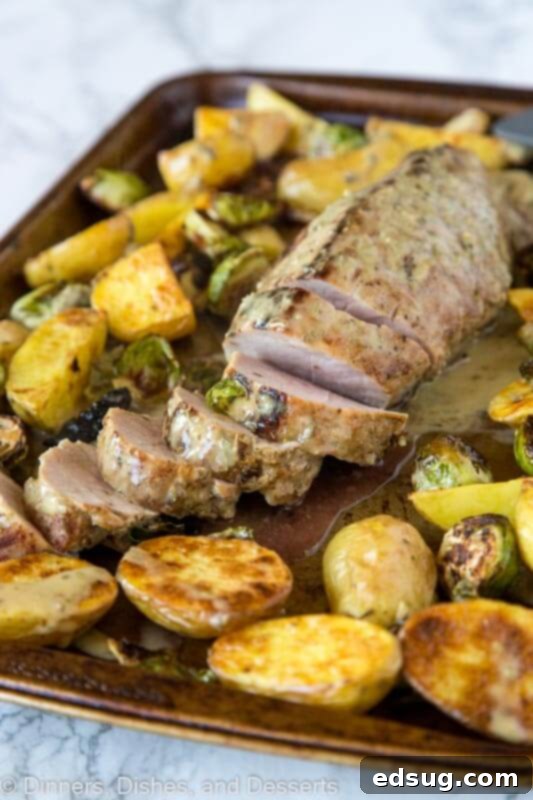 One-Pan Pork Tenderloin Dinner 2 A tray of perfectly cooked sheet pan pork tenderloin, roasted potatoes, and Brussels sprouts, ready to serve.