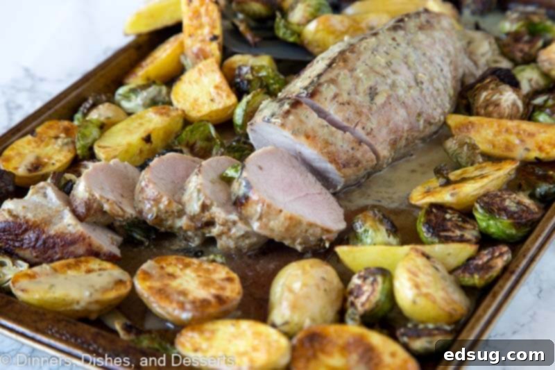 One-Pan Pork Tenderloin Dinner 4 Sliced Sheet Pan Pork Tenderloin with roasted vegetables on the pan, showcasing the delicious crust.