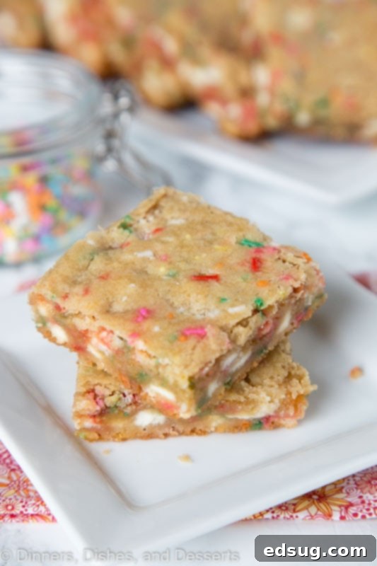 coconut blondies with white chocolate chips and sprinkles stacked on a plate