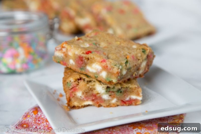 coconut blondies with white chocolate chips and sprinkles stacked on a plate