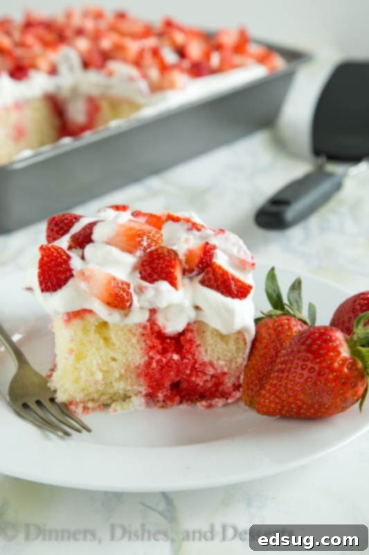 Poke cake with strawberry jello and fresh shipped cream in white pate