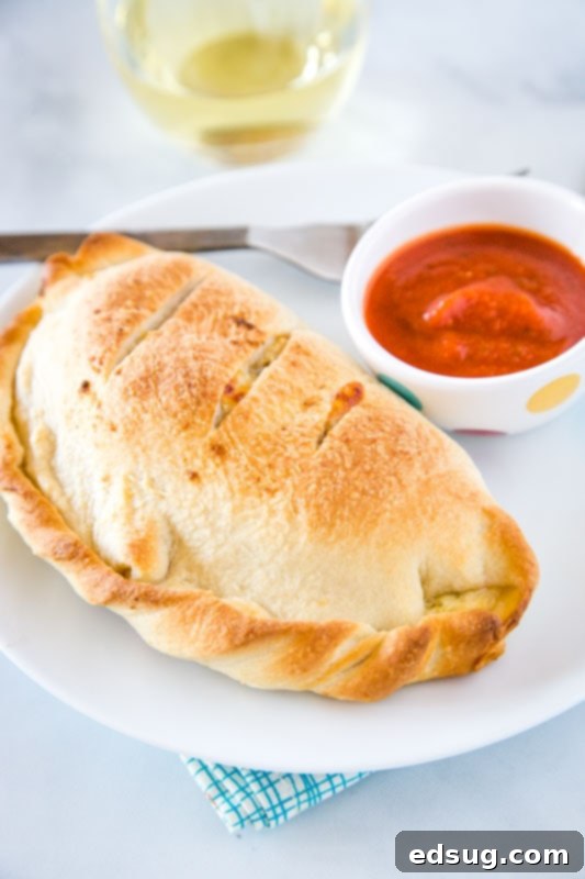 Folded Pizza Pockets 2 Homemade calzones filled with 3 cheesees, sausage, and pepperoni, golden brown and ready to eat