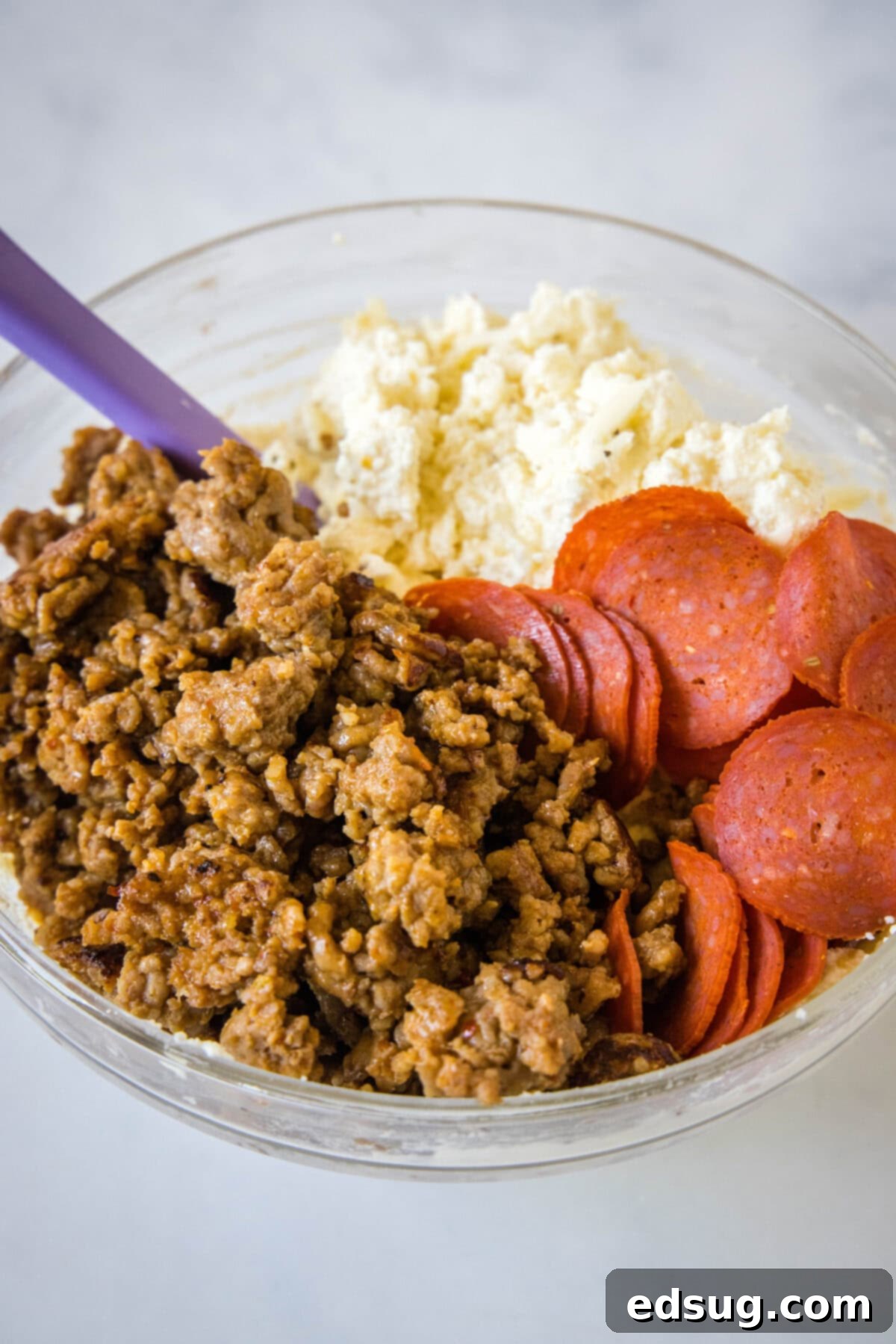 Folded Pizza Pockets 4 A large mixing bowl filled with the creamy calzone filling, including ricotta, mozzarella, Parmesan, cooked sausage, and pepperoni.