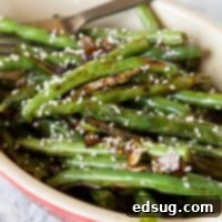 roasted green beans in a dish with sesame seeds