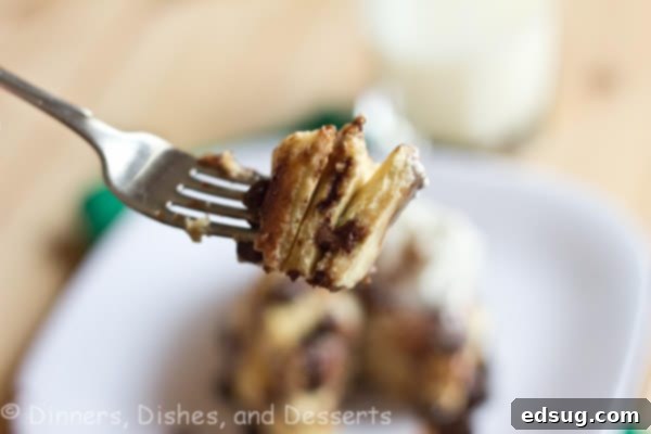 A delightful stack of fluffy chocolate chip cookie pancakes, garnished with whipped cream, chocolate syrup, and extra chocolate chips, presented on a pristine white plate. Perfect for a gourmet breakfast or brunch.