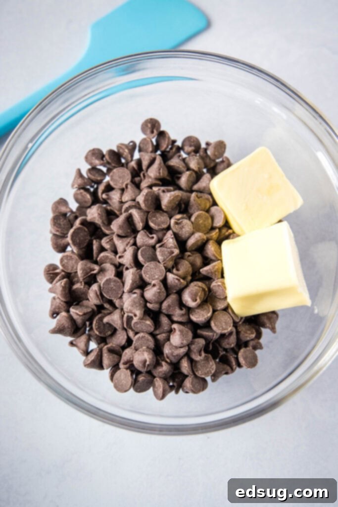 Decadent Chocolate Fudge Cookies 3 Close-up of semi-sweet chocolate chips and cubes of butter in a mixing bowl, ready to be melted for making homemade brownie cookies.