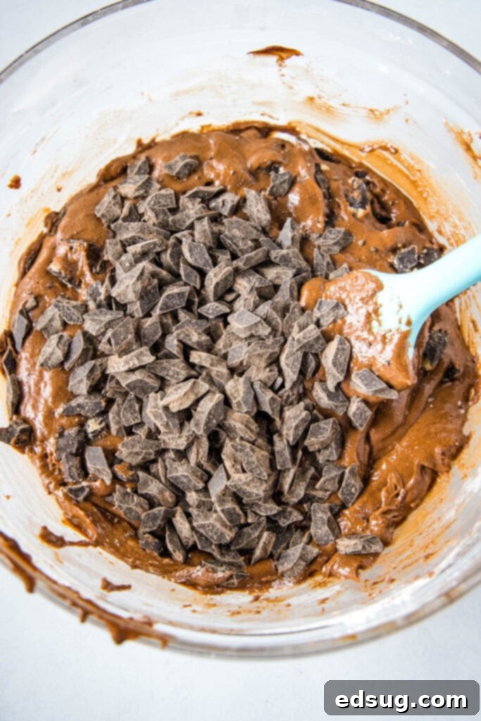 Decadent Chocolate Fudge Cookies 4 Close-up of sticky, thick brownie cookie dough generously studded with chocolate chunks, perfectly ready for baking.