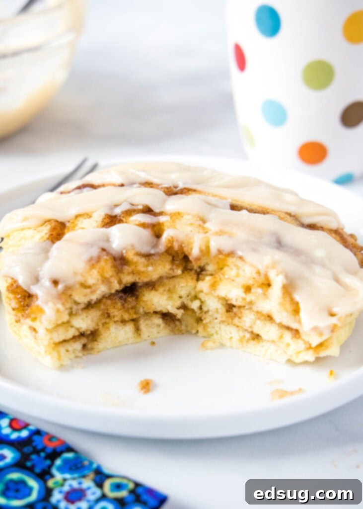 Cinnamon Swirl Pancakes 4 bite taken out of stack of pancakes