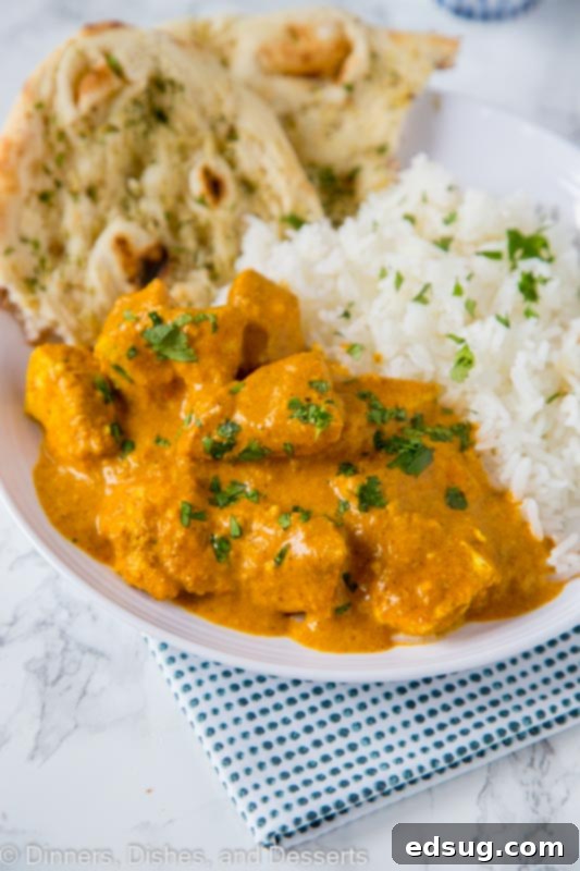 The Ultimate Homemade Chicken Tikka Masala 4 A serving of Chicken Tikka Masala alongside fluffy white rice, garnished with fresh herbs, showcasing a complete meal.