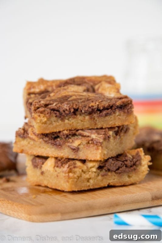Blondies swirled with nutella stacked on a cutting board