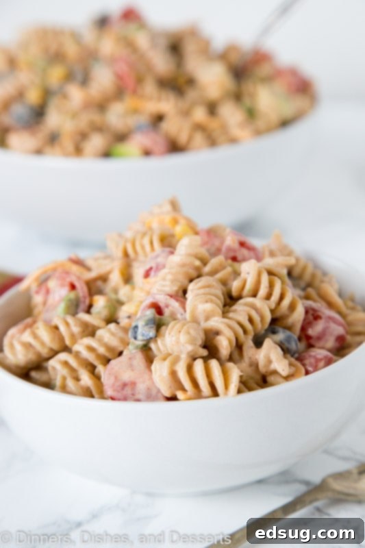 A closer look at the delicious ingredients mixed together in the taco pasta salad, showing the creamy dressing coating the pasta and vegetables.