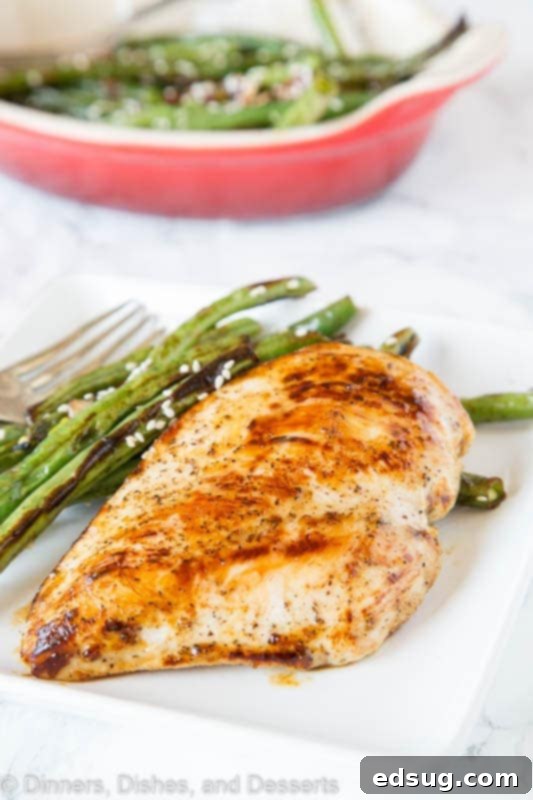 A beautifully plated Honey Dijon Chicken dish with a side of vegetables.