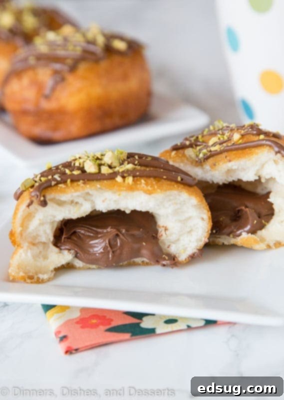A Nutella donut cut in half, revealing the rich hazelnut chocolate filling nestled inside.