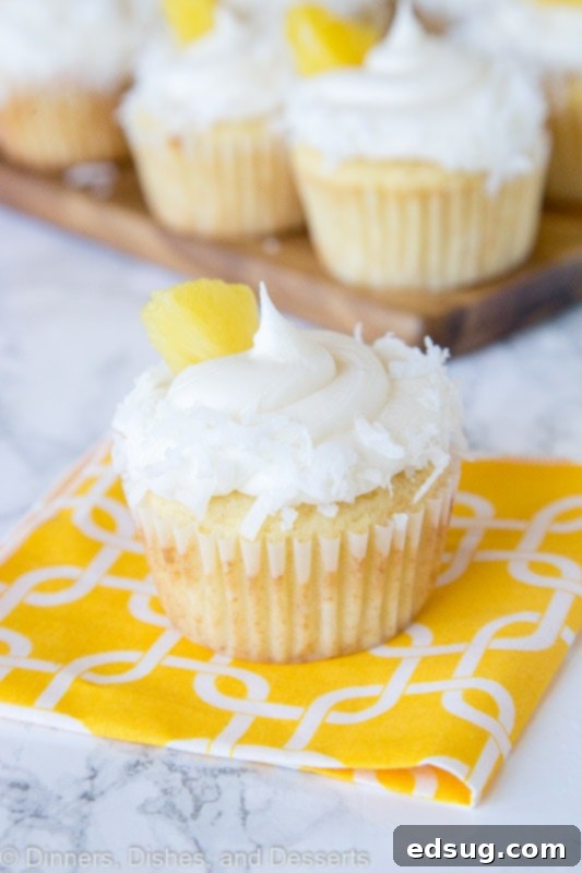 A close up of A close up pineapple cupcakes with coconut and pineapple piece