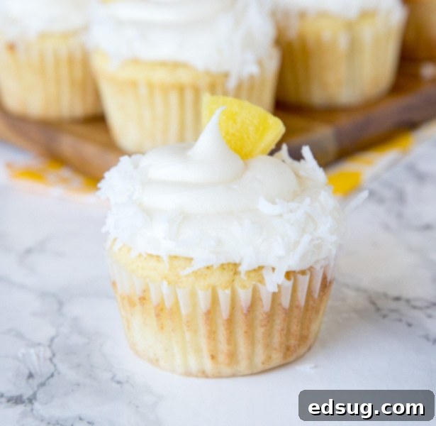 A close up of A close up pineapple cupcakes with coconut and pineapple piece