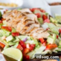 Chicken Fajita Salad - a hearty salad topped with grilled chicken, peppers, onion, avocados, and a salsa vinaigrette dressing. Definitely not your average salad!