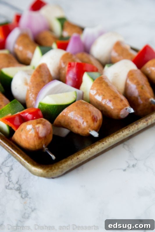 Sizzling Sausage and Veggie Kebabs 4 sausage and veggie kebabs before the grill on a tray