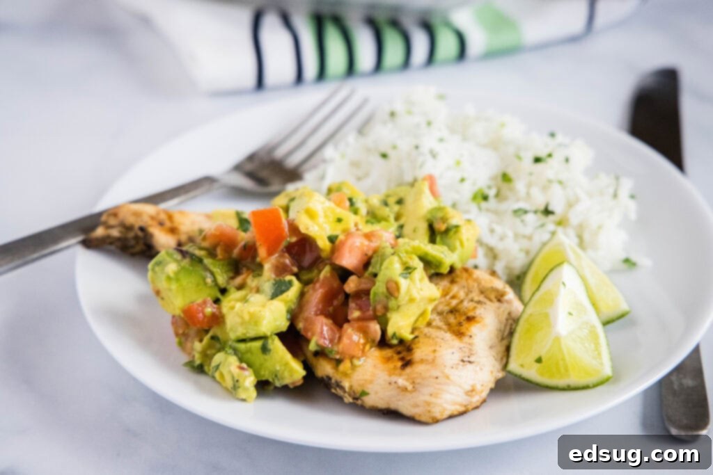 A vibrant bowl of avocado salsa with fresh lime wedges, ready to be served.