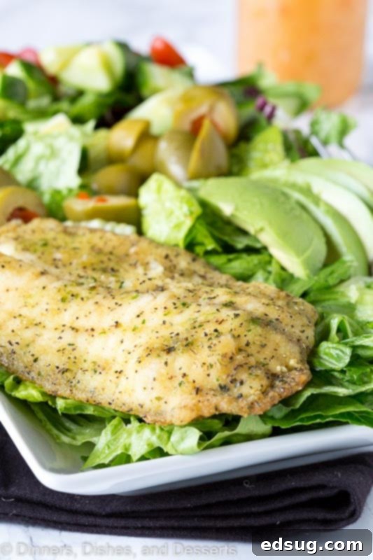 Mediterranean Garlic Herb Salad 3 Close-up of a fresh salad with grilled garlic and herb fish, drizzled with lemon vinaigrette