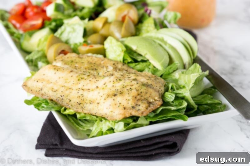 Mediterranean Garlic Herb Salad 4 Mediterranean salad on a white plate with grilled garlic herb tilapia on top and fresh vegetables