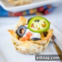 Close-up of perfectly golden wonton taco cups, arranged as an inviting recipe card visual, showcasing their delicious texture and filling.