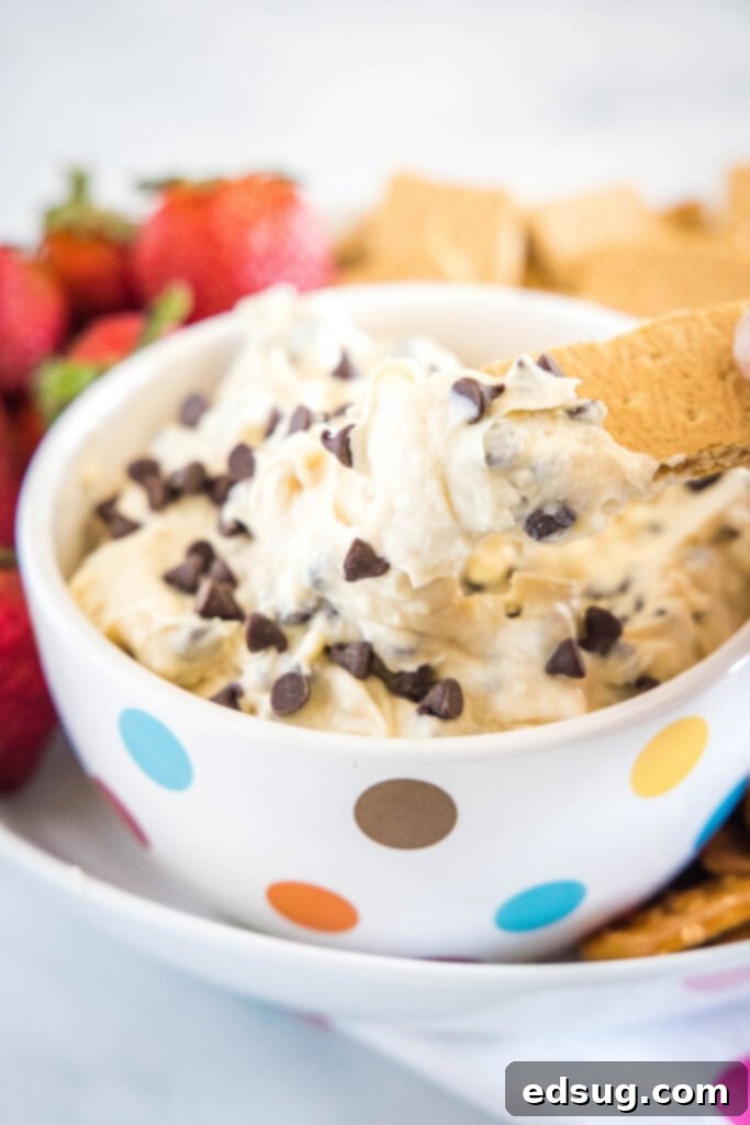 scooping cookie dough dip out with a graham cracker