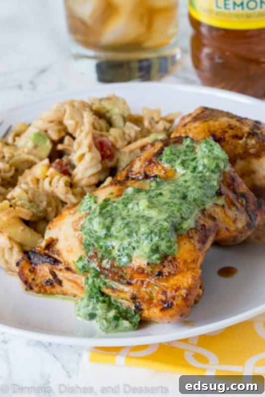 Chargrilled Chicken Thighs 2 A plate of perfectly grilled chicken thighs topped generously with a vibrant green herb sauce, ready to be enjoyed.