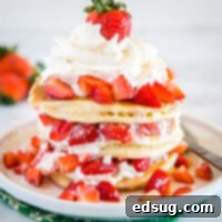 Dreamy Strawberry Shortcake Pancakes 7 Pancakes layered with whipped cream and strawberries, a delicious visual.