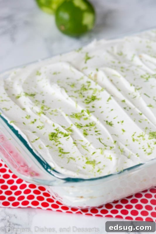 Key lime icebox cake cooling in a rectangular baking dish on a wooden table