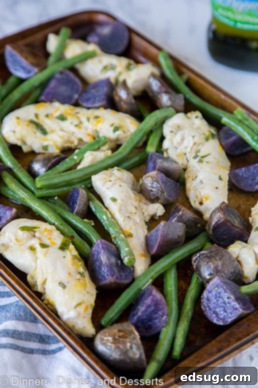 Crispy Roast Chicken and Potatoes 4 chicken, green beans and purple potatoes on a baking tra