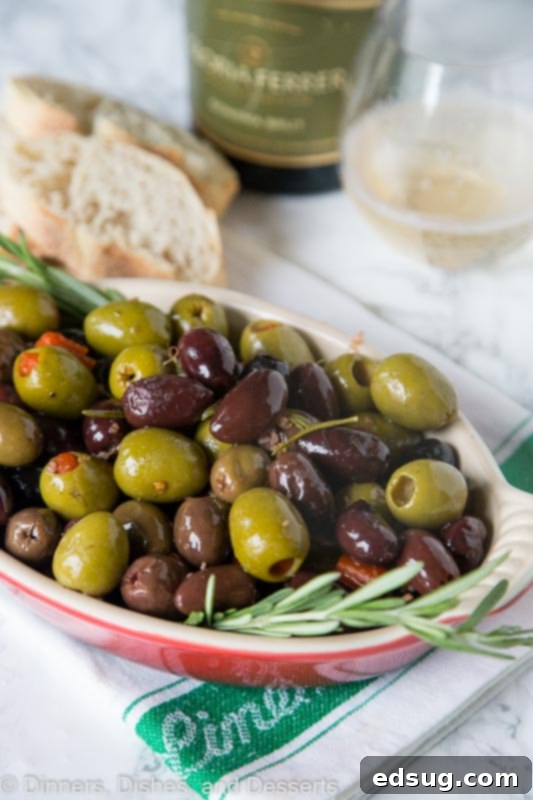 A stylish shot of a bowl of roasted olives with rosemary, ready to be served as an appetizer.
