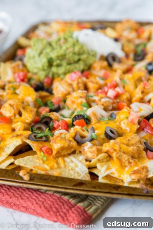 Loaded Sheet Pan Chicken Nachos 2 Delicious sheet pan chicken nachos loaded with melted cheese and fresh toppings, ready to serve.