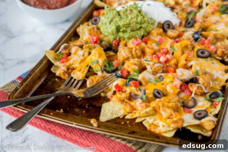 Loaded Sheet Pan Chicken Nachos 4 Close-up of a generously loaded sheet pan of chicken nachos with vibrant toppings.