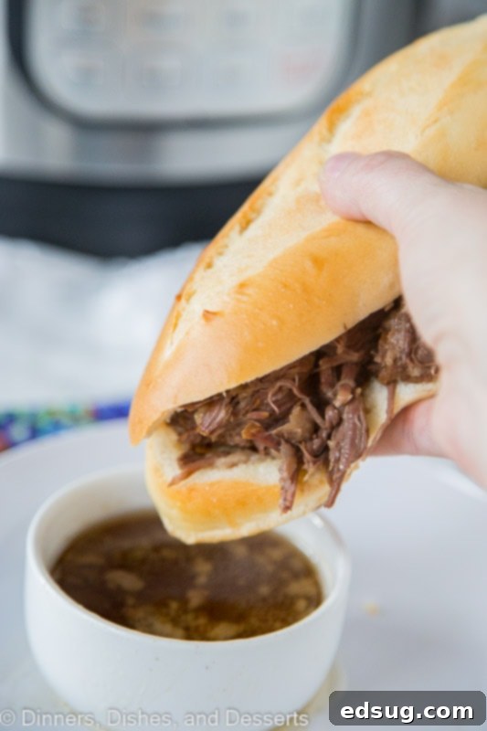 Melt-in-Your-Mouth Instant Pot French Dip Sandwiches 3 a person holding A French dip sandwich