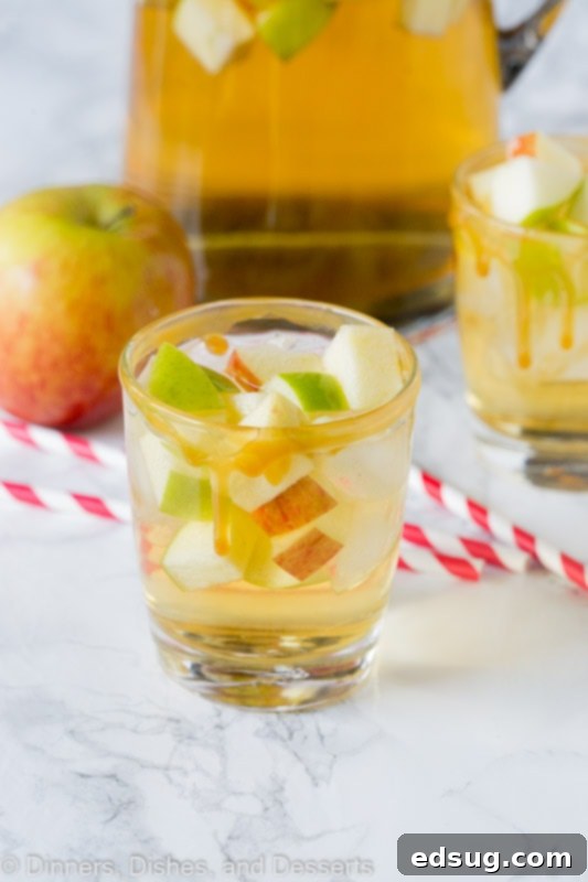 apple sangria in a glass with red and white straws