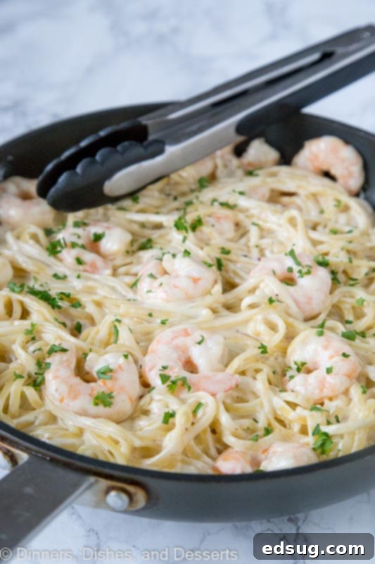 A vibrant close-up of One-Pan Fettuccine Alfredo with succulent shrimp, promising a simple, romantic, and easy meal for any night of the week.