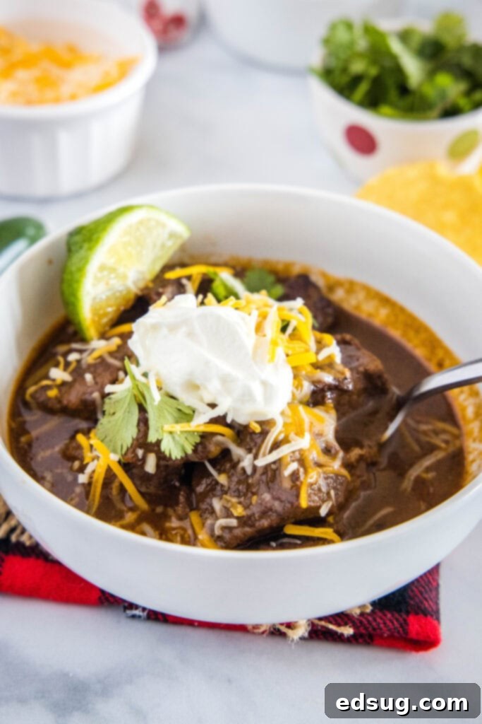 Authentic Texas Chili 4 A bowl of rich, hearty Texas-style chili, generously topped with shredded cheese and a dollop of sour cream, ready for a comforting meal.