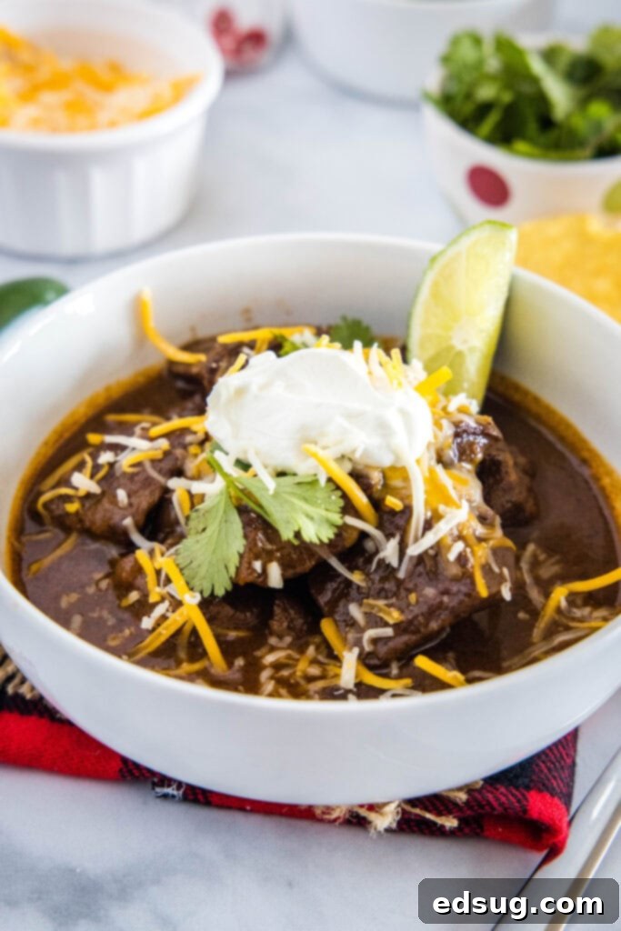 Authentic Texas Chili 5 A comforting bowl of Texas chili, generously garnished with melted cheese and a dollop of cool sour cream, promising a delicious and satisfying meal.