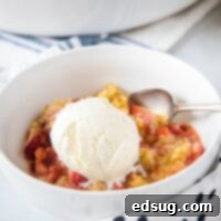 strawberry crisp without oats close up in a bowl with ice cream on top