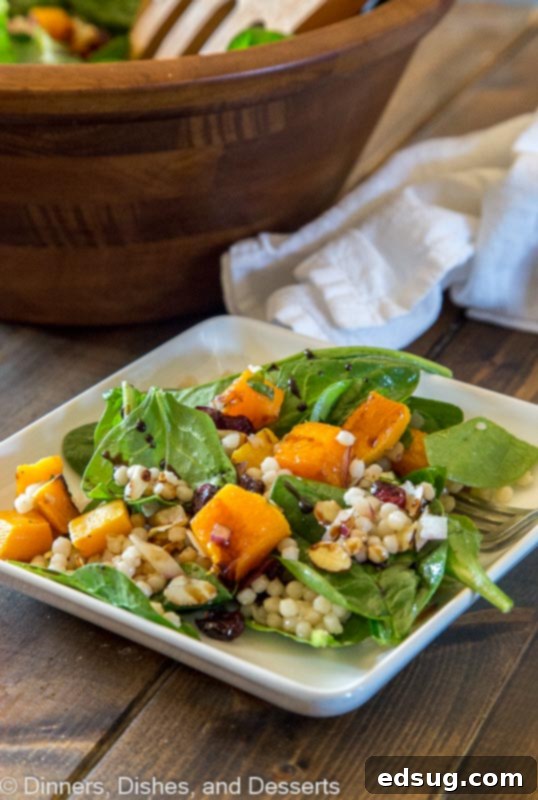 Fall Couscous salad featuring Israeli couscous, roasted butternut squash, fresh spinach, tart cranberries, and crunchy pecans