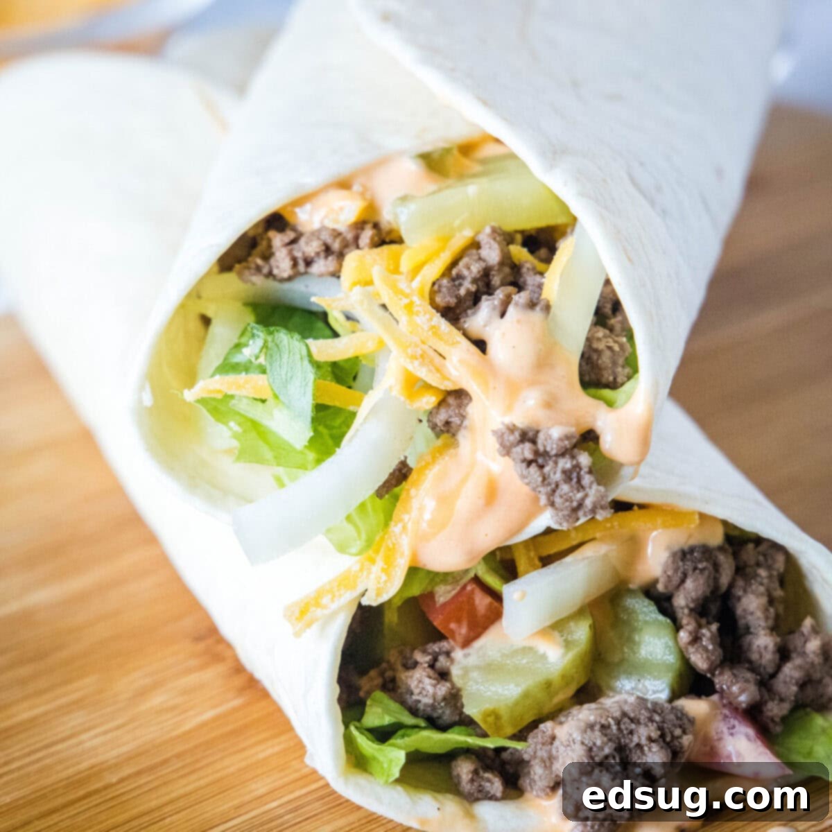 Two deliciously prepared Big Mac Wraps, showcasing juicy beef, fresh vegetables, and special sauce, stacked diagonally.