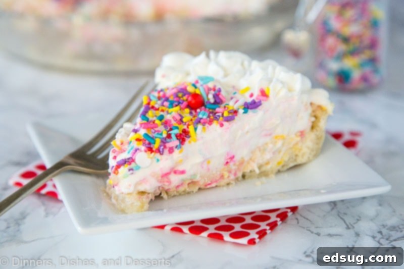Celebration Funfetti Cheesecake Pie 3 A close-up of a whole Funfetti Cheesecake Pie, showcasing its golden-brown crust, creamy filling, fluffy mousse topping, and generous scattering of rainbow sprinkles.