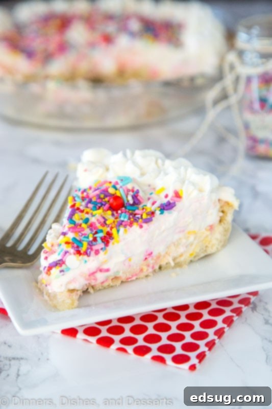 Celebration Funfetti Cheesecake Pie 4 A side view of a slice of Funfetti Cheesecake Pie, showing off its distinct layers of crust, cheesecake, and mousse, with vibrant sprinkles throughout.