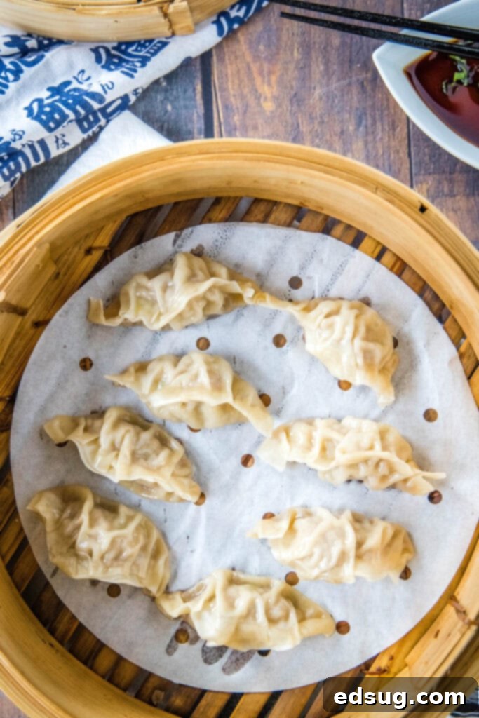 Freshly made steamed pork dumplings resting in a bamboo steamer basket, ready to be served with dipping sauce.
