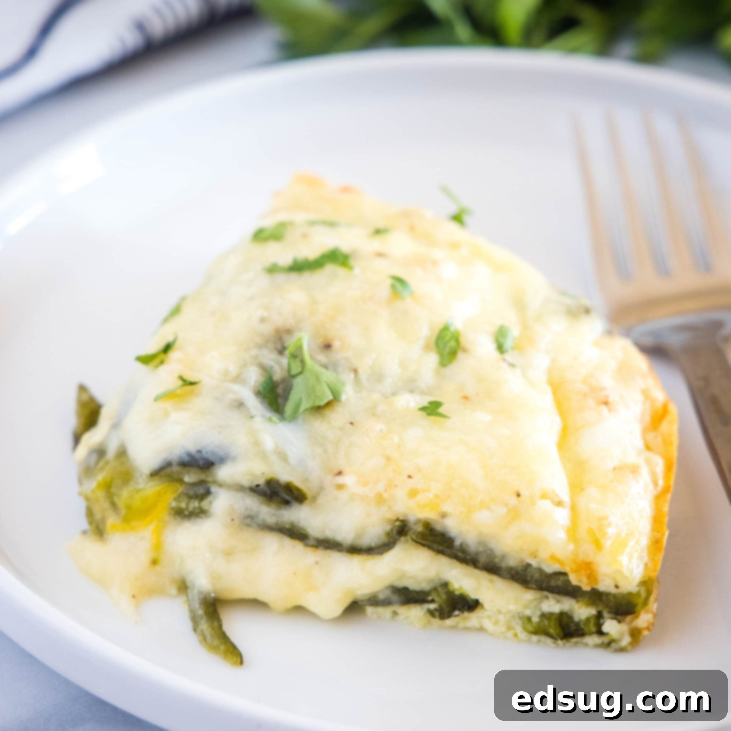 cropped close up of chili relleno casserole on a plate with a fork