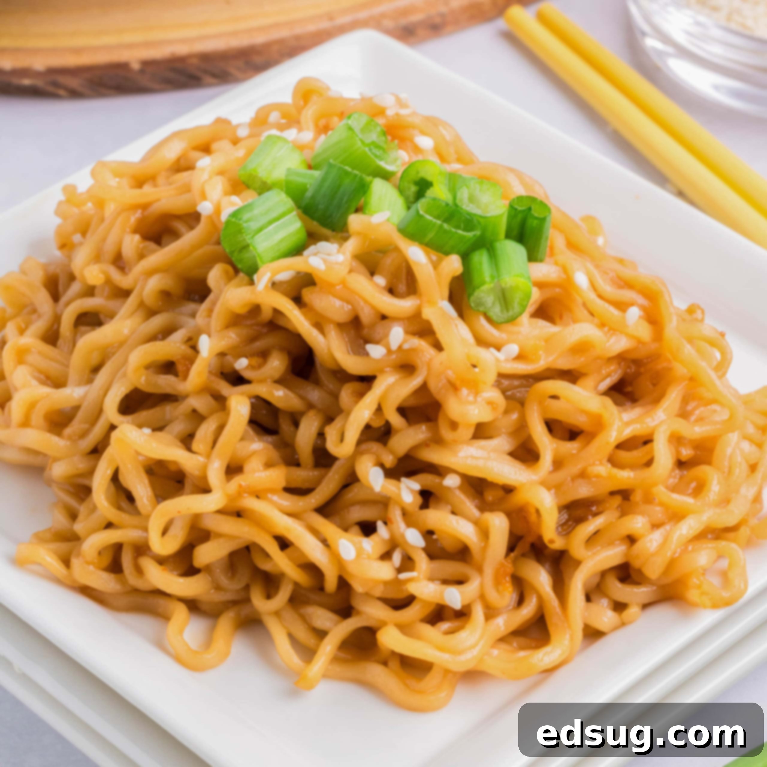 cropped close up sesame noodles on a plate with green onions