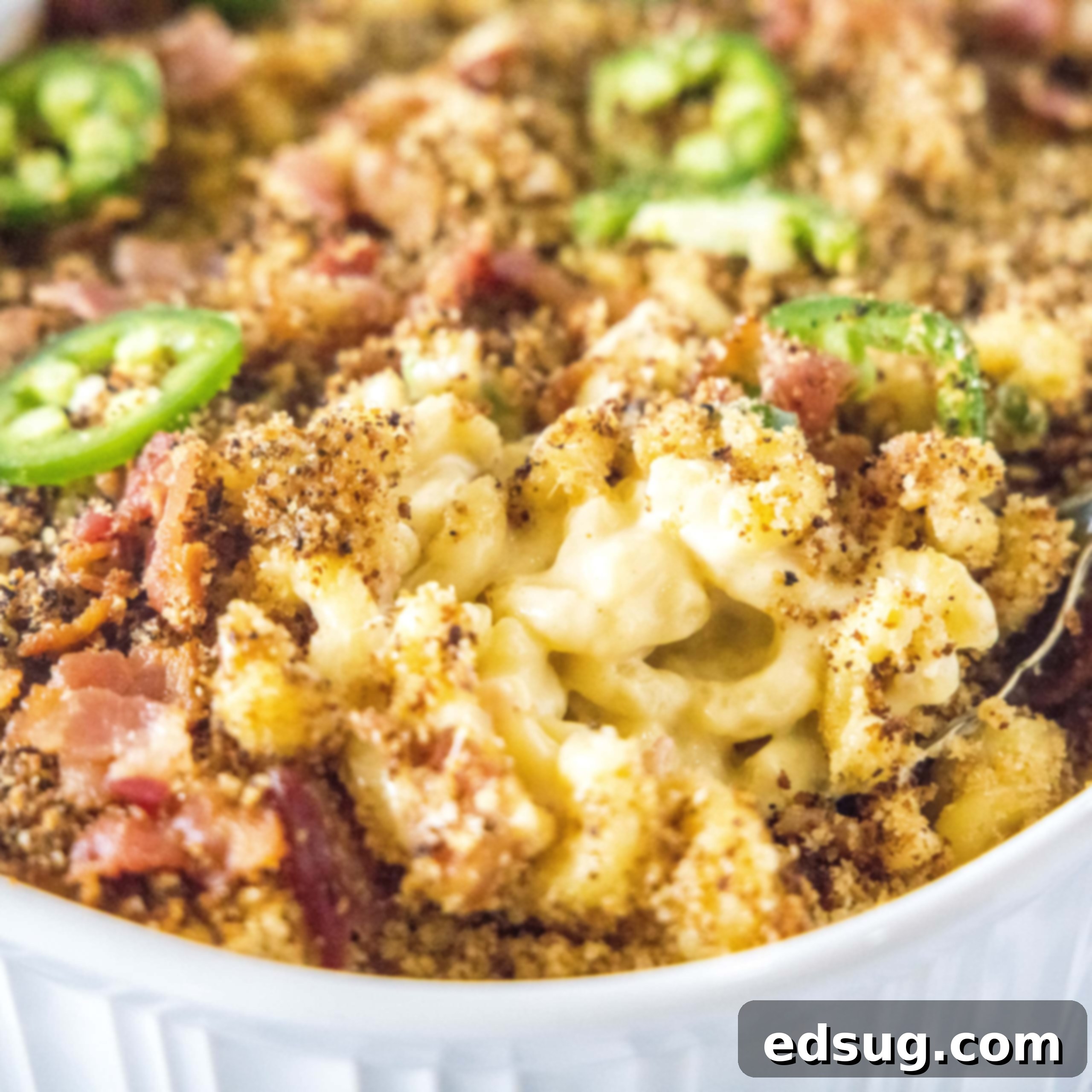 close up spooning mac and cheese from baking dish
