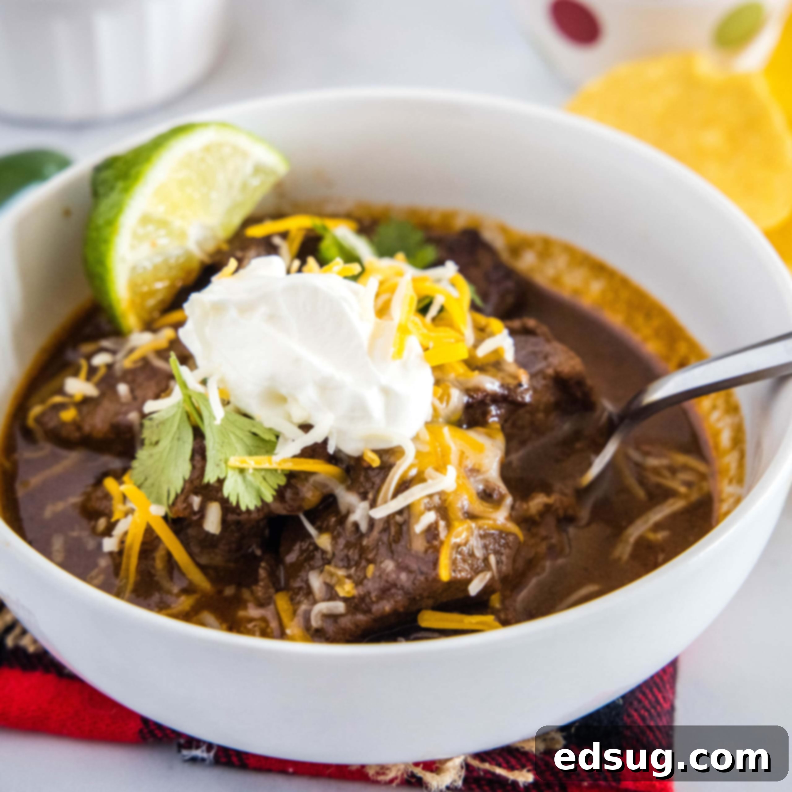 cropped image of beef chili topped with cheese and sour cream