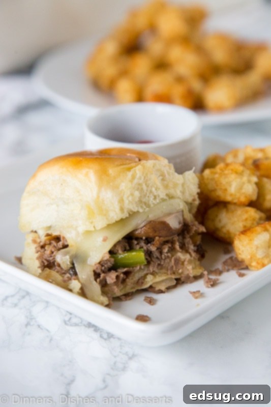 Philly Cheesteak Sliders - slider recipes are great for game day or when throwing a party A stacked plate of cooked Philly Cheesesteak Sliders, ready to be enjoyed, highlighting their perfect party size.